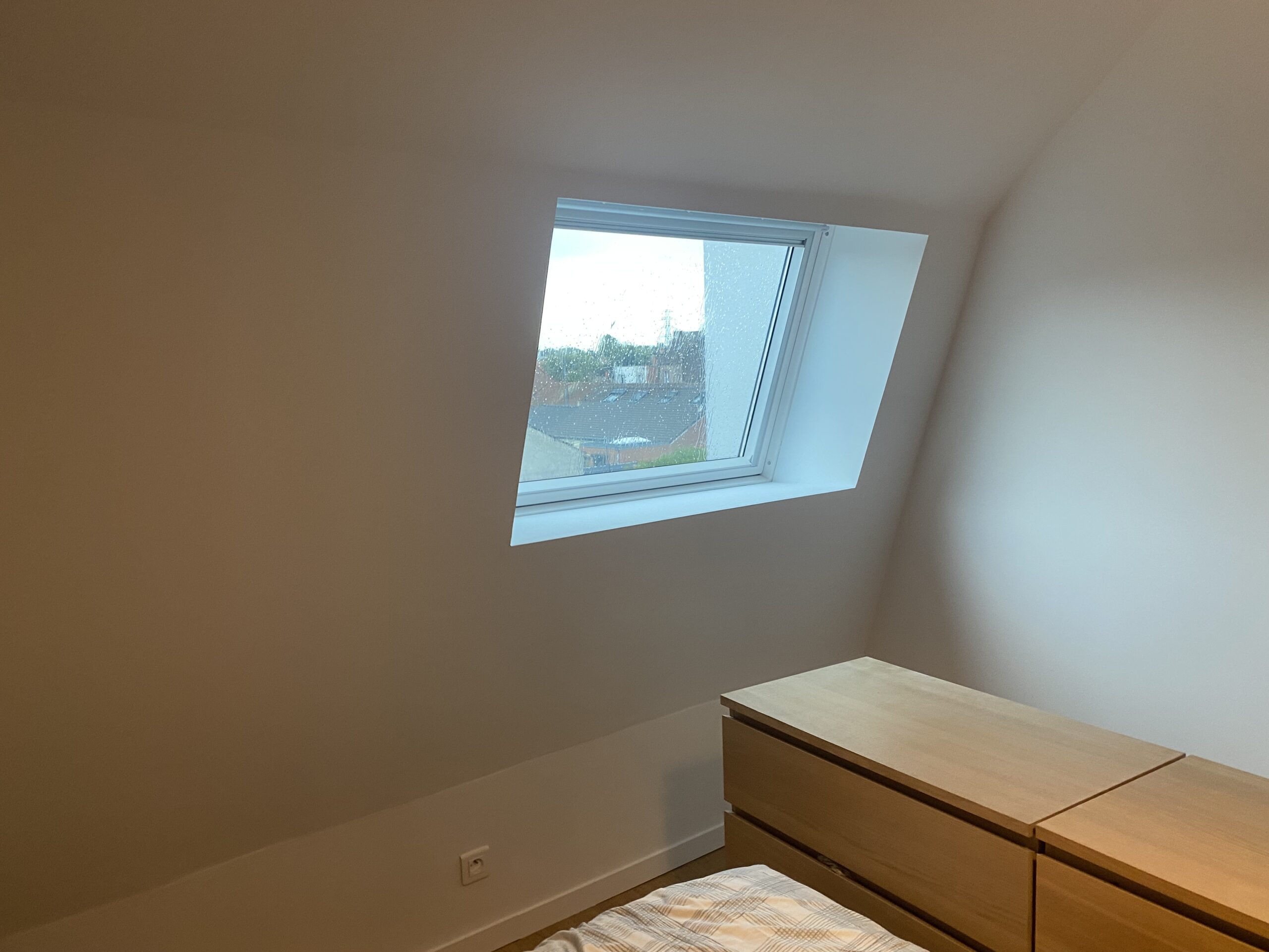 Chambre sous combles avec habillage de velux en plaques de plâtre, finition peinte