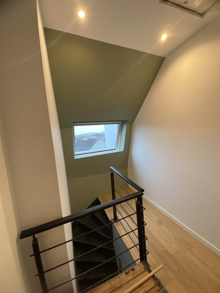 Cage d’escalier sous combles avec habillage de velux en plaques de plâtre, enduit et peint